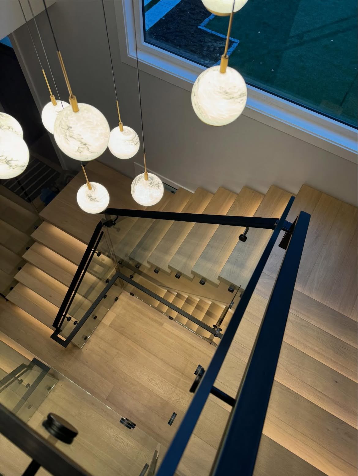 Glass staircase under pendant lights