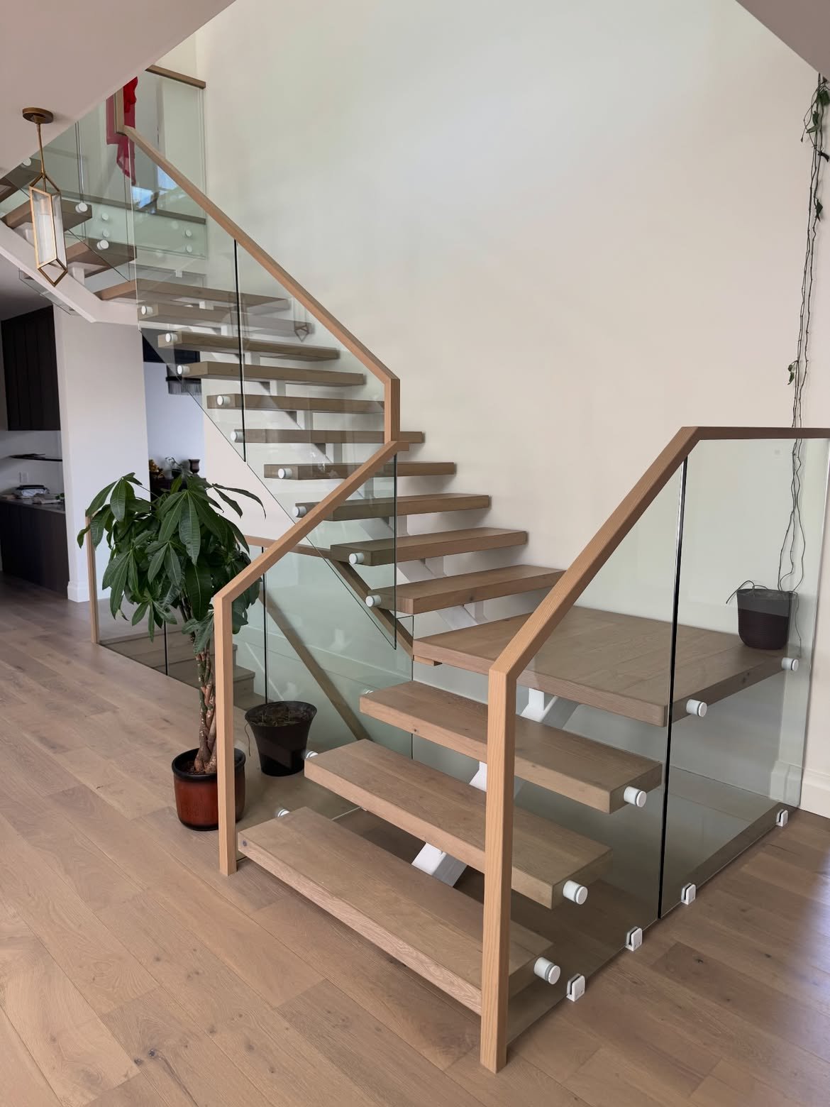 Wood and glass staircase with light handrails